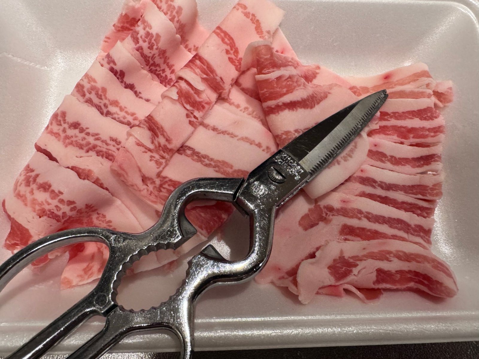 豚バラ肉をキッチンバサミで切る