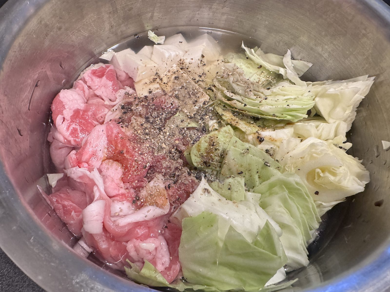 ホットクックの内鍋に入れた豚こま肉・キャベツ・豆腐と調味料