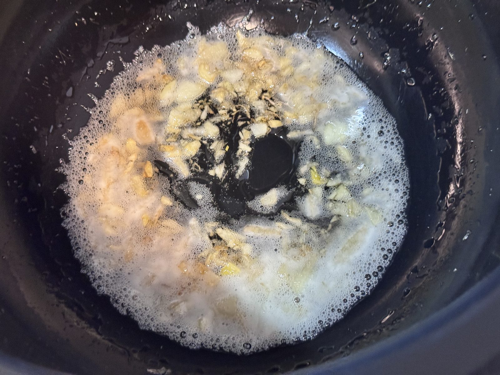 米油でにんにくと生姜を炒めているホットクックの内鍋