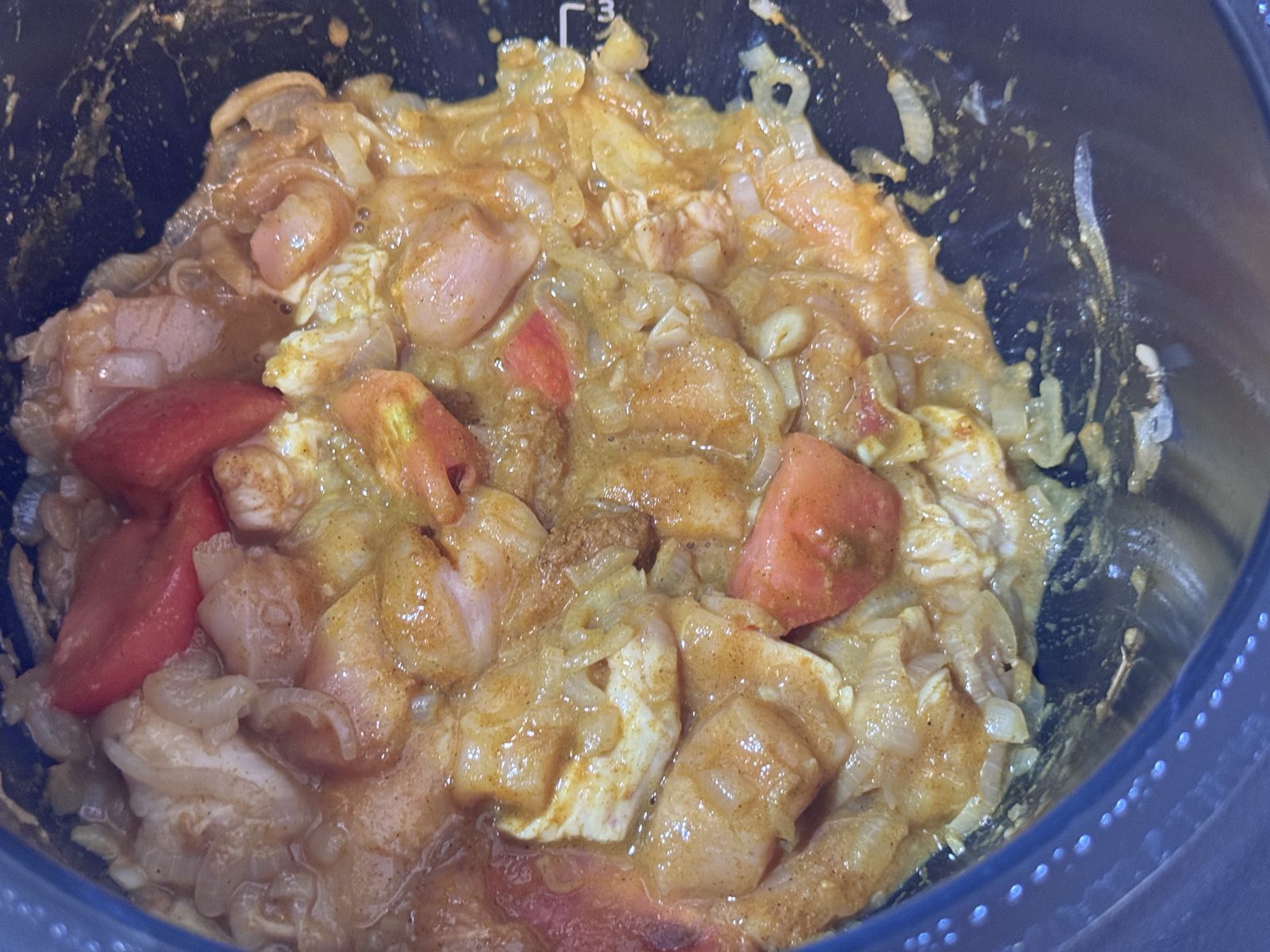 カレー粉を全体に混ぜた鶏むね肉とトマト