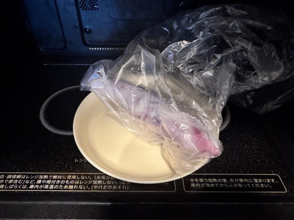 ぬらしたキッチンペーパーで包んださつまいもをアイラップに入れて皿にのせ、レンジに入れたところ